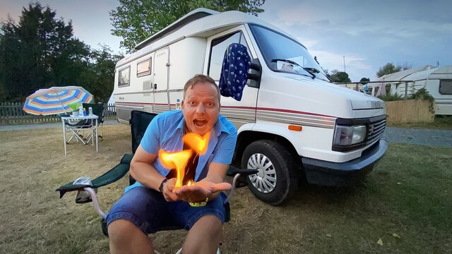 Friso Richter vor seinem Camper - mit Feuer auf der Hand. 