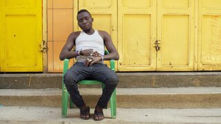 Monobloc in Afrika. Ein Mann sitzt auf einem Stuhl